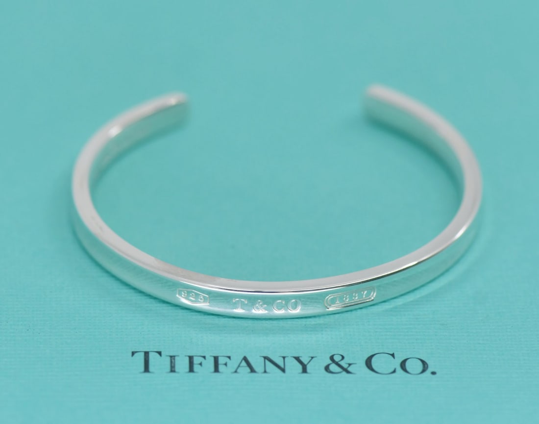 Sterling Silver Cuff Bracelet by Tiffany & Co with Pouch: Sterling Silver Cuff Bracelet by Tiffany & Co with Pouch This Tiffany & Co. cuff bracelet is crafted from 925 sterling silver and features a sleek, minimalist design without any stones. It is made in