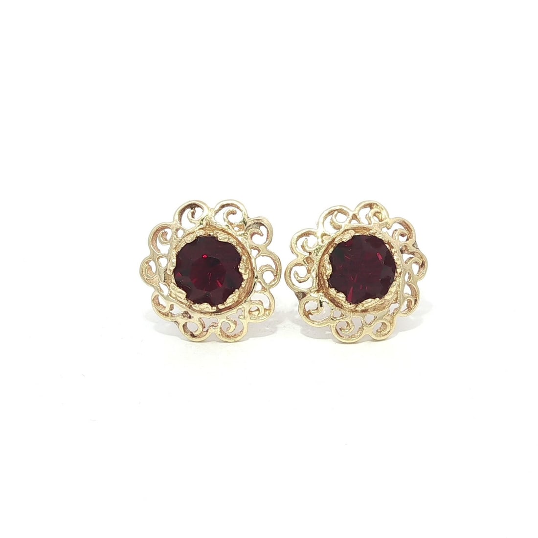 Vintage 14k Yellow Gold Floral Stud Earrings with Round Garnet: Vintage 14k Yellow Gold Floral Stud Earrings with Round Garnet These vintage stud earrings are crafted from solid 14k yellow gold and feature a beautiful open work floral design. Each earring is adorn
