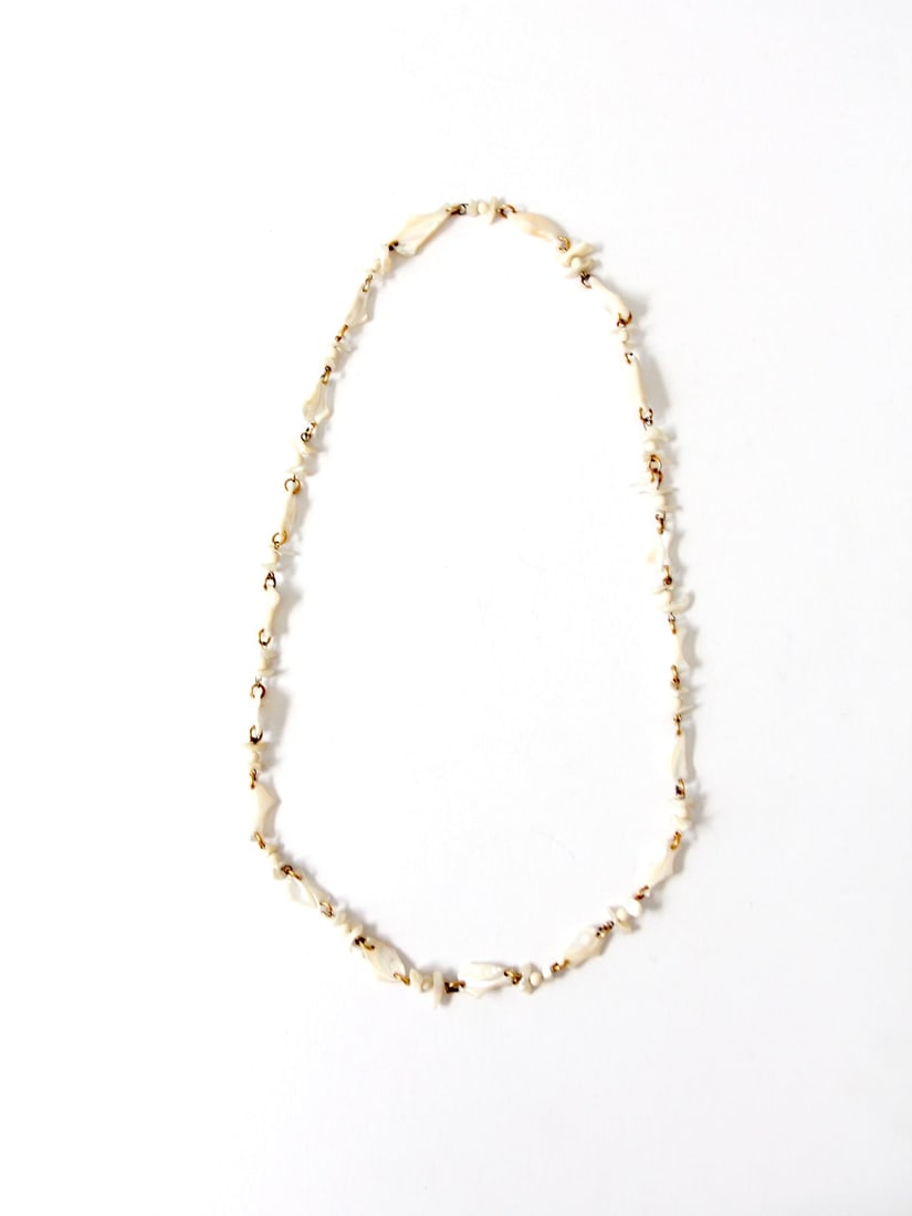 Vintage Mother of Pearl Necklace with Gold Tone Rings 36": Vintage Mother of Pearl Necklace with Gold Tone Rings 36" This vintage mother of pearl necklace features a stunning array of natural beads that create a long, elegant strand, accented with gold tone r