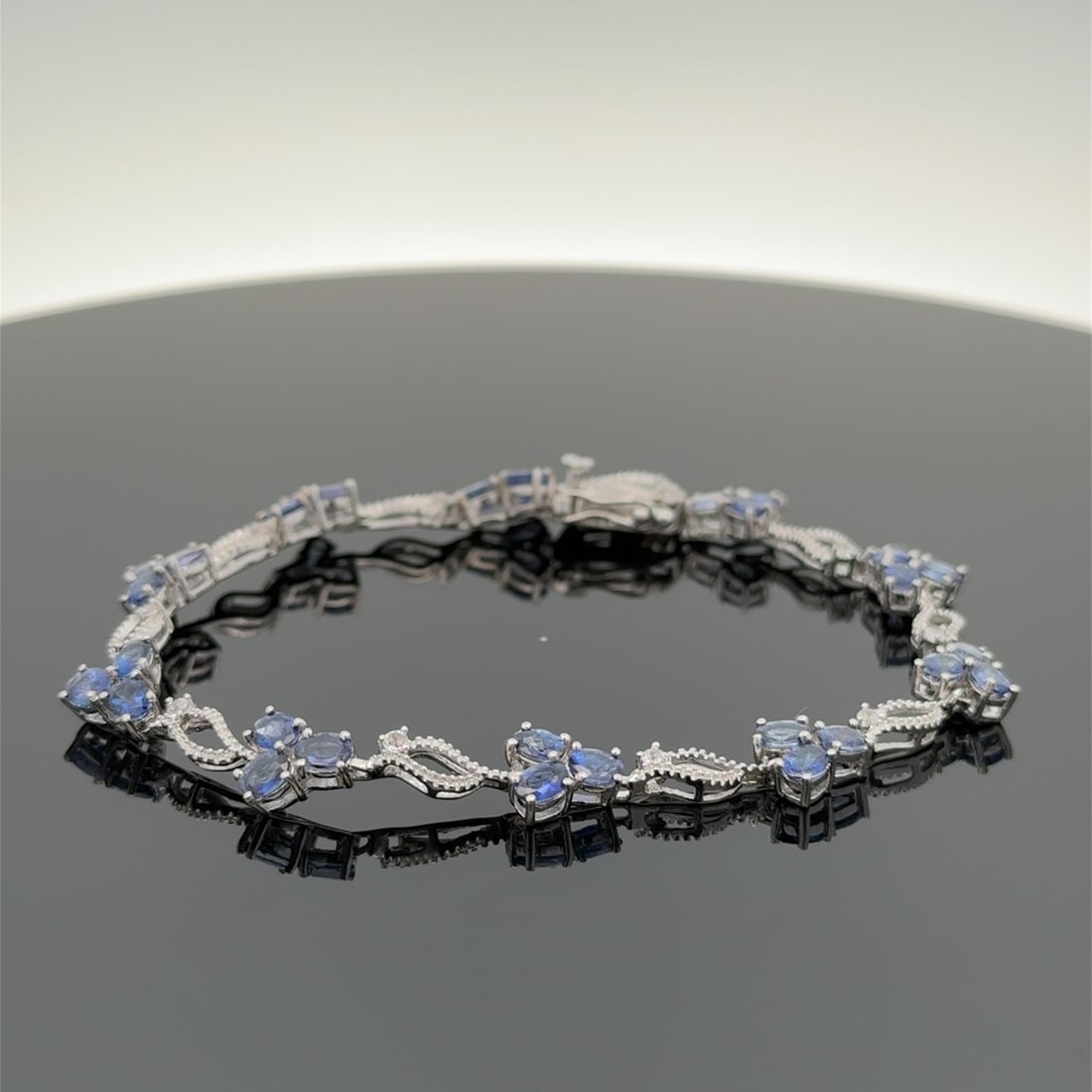 Sterling Silver Link Tennis Bracelet with Tanzanite and White Topaz Accents: Sterling Silver Link Tennis Bracelet with Tanzanite and White Topaz Accents This exquisite tennis bracelet features a stunning array of natural genuine Tanzanite clusters and sparkling white topaz acc