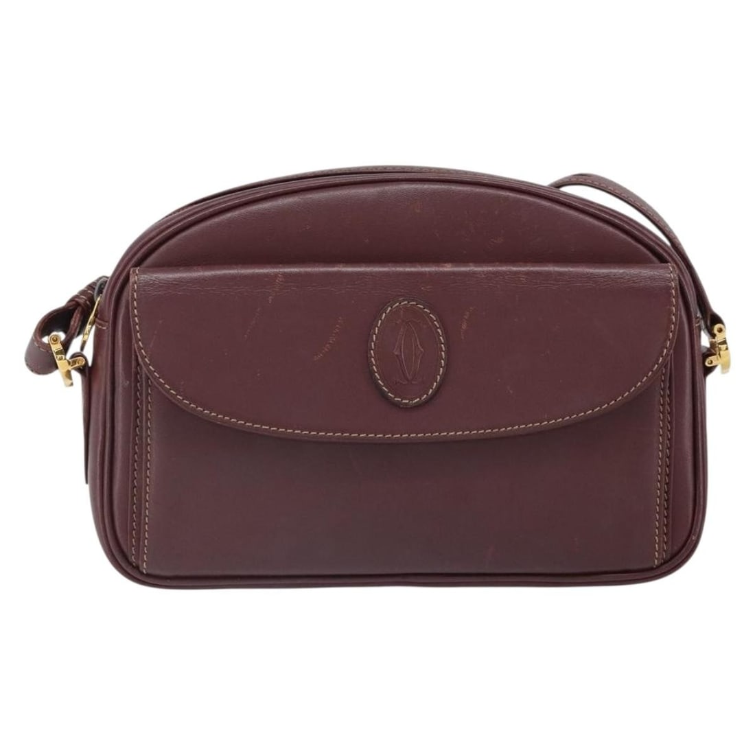 Burgundy Leather Shoulder Bag by Cartier Must de Cartier: Burgundy Leather Shoulder Bag by Cartier Must de Cartier This Must de Cartier shoulder bag for women features burgundy leather with a classic design. It shows signs of wear including surface rubbing,