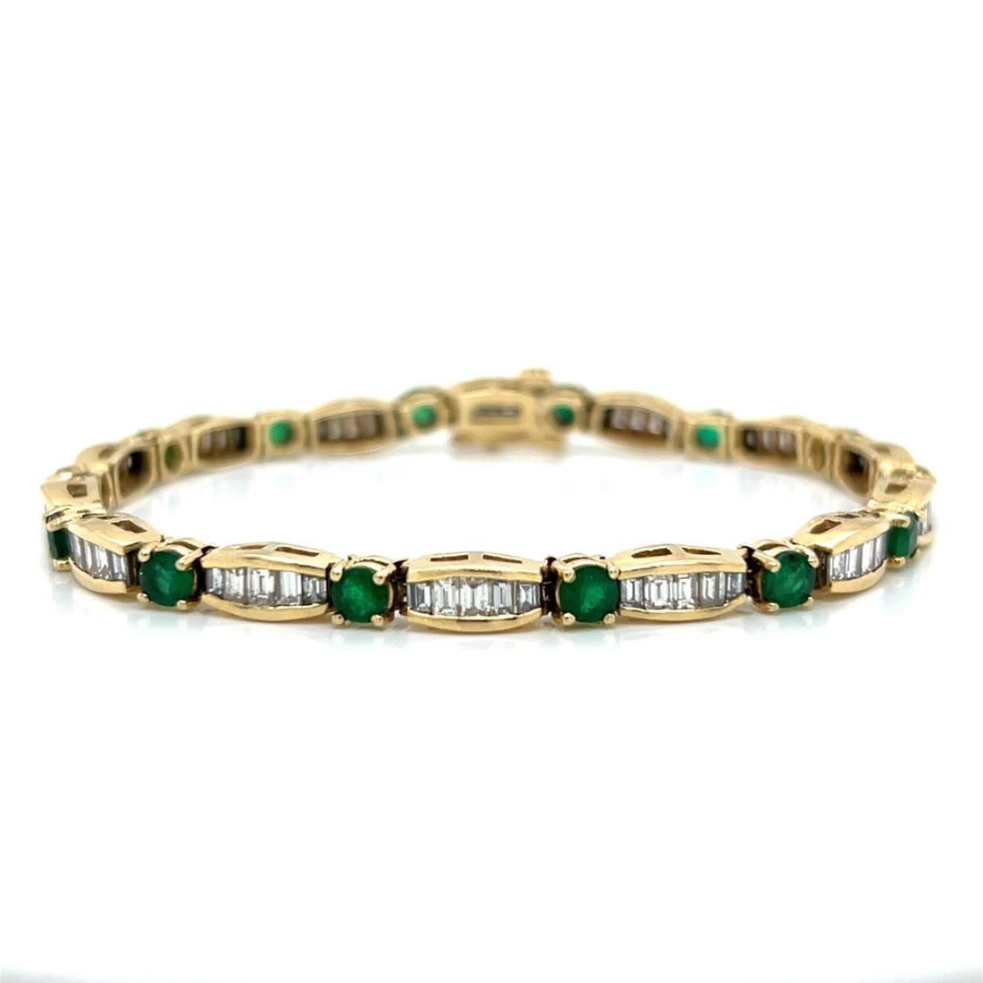 Emerald and Diamond Bracelet in 14K Yellow Gold 7.25 Inch Length: Emerald and Diamond Bracelet in 14K Yellow Gold 7.25 Inch Length This pre-owned bracelet is crafted from 14K yellow gold and features a combination of 70 baguette diamonds with an approximate total we