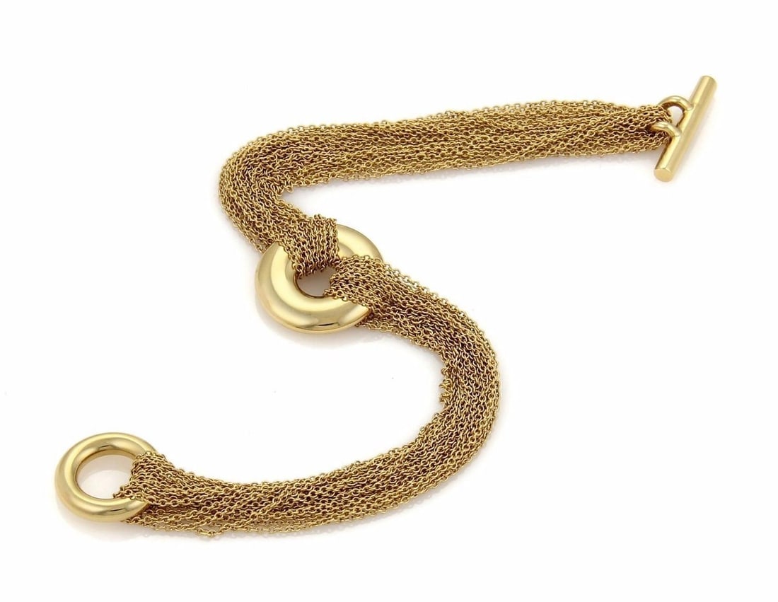 18k Yellow Gold Multi Chain Bracelet with Circle Charm by Tiffany & Co.: 18k Yellow Gold Multi Chain Bracelet with Circle Charm by Tiffany & Co. This Tiffany & Co. bracelet is crafted from 18k yellow gold and features a multi-strand chain design with a circle charm and a t