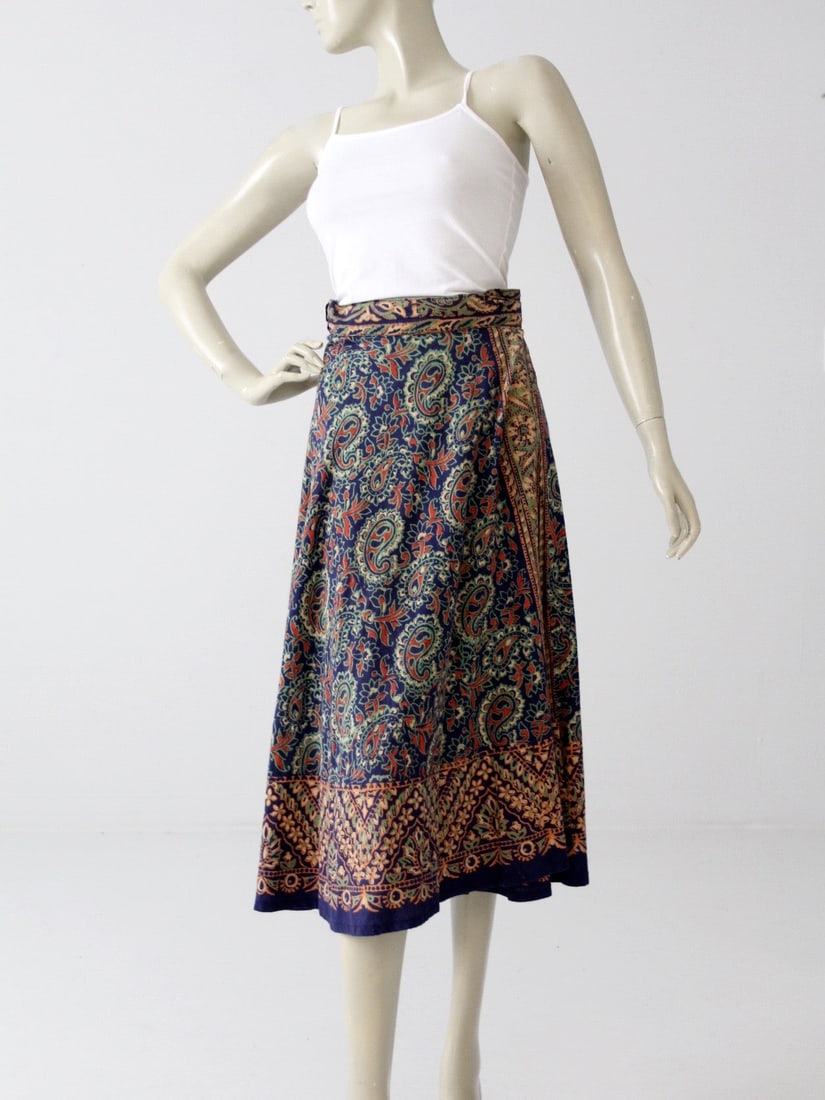 1970s Vintage Bohemian Navy Wrap Skirt with Paisley Print: 1970s Vintage Bohemian Navy Wrap Skirt with Paisley Print Step back into the vibrant 1970s with this stunning vintage bohemian wrap skirt. Crafted from soft India cotton, this navy skirt showcases a s