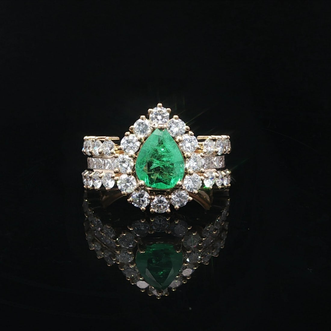 18k Yellow Gold Pear Emerald and Diamond Cocktail Ring 3.3ctw: 18k Yellow Gold Pear Emerald and Diamond Cocktail Ring 3.3ctw This cocktail ring is crafted in solid 18k yellow gold and features a natural pear-cut emerald as the centerpiece, accented by round brill