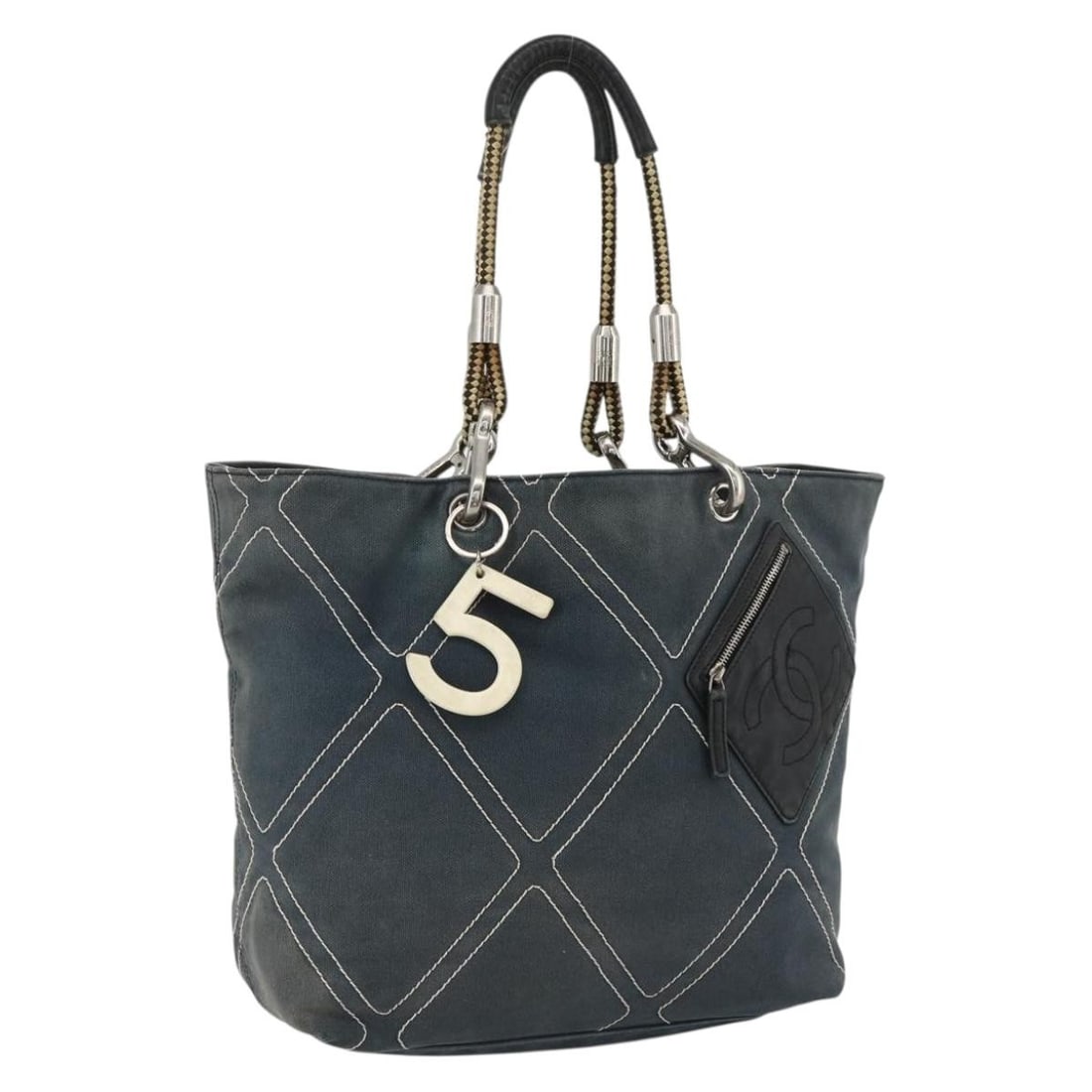 Navy Canvas Tote Bag by CHANEL with Silver CC Logo: Navy Canvas Tote Bag by CHANEL with Silver CC Logo This CHANEL tote bag features a navy and silver canvas exterior with the signature CC logo. Designed for women, it offers ample space and classic sty