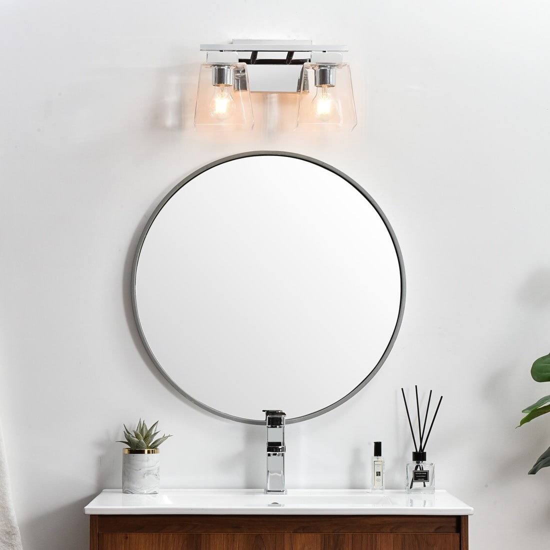 Merrick 14 Inch Chrome Modern Wall Sconce With Two Lights and Glass Shades: Merrick 14 Inch Chrome Modern Wall Sconce With Two Lights and Glass Shades This modern wall sconce features a polished chrome finish and two lights with dome-shaped clear glass shades. Designed for