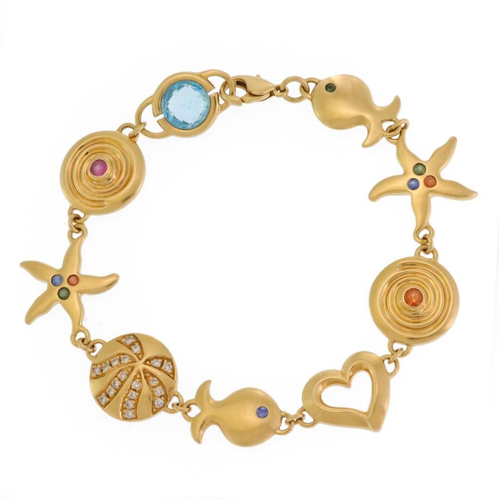 Signed Michelle 18k Gold Sea Life Bracelet with Diamond and Gemstones: Signed Michelle 18k Gold Sea Life Bracelet with Diamond and Gemstones This exquisite signed Michelle bracelet is crafted from 18k yellow gold, showcasing a smooth polished finish. The intricate links 