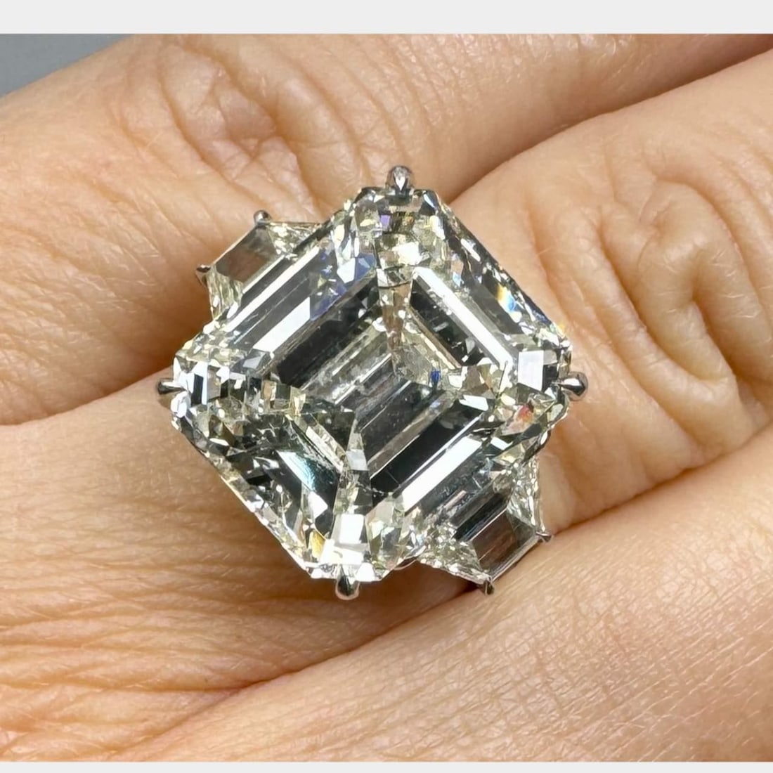 15.22 Ct Emerald-Cut Diamond Platinum Ring with 2 Accent Diamonds: 15.22 Ct Emerald-Cut Diamond Platinum Ring with 2 Accent Diamonds This stunning platinum ring features a remarkable 15.22 Ct. emerald-cut diamond, showcasing a J-K color and SI2 clarity. The ring is a