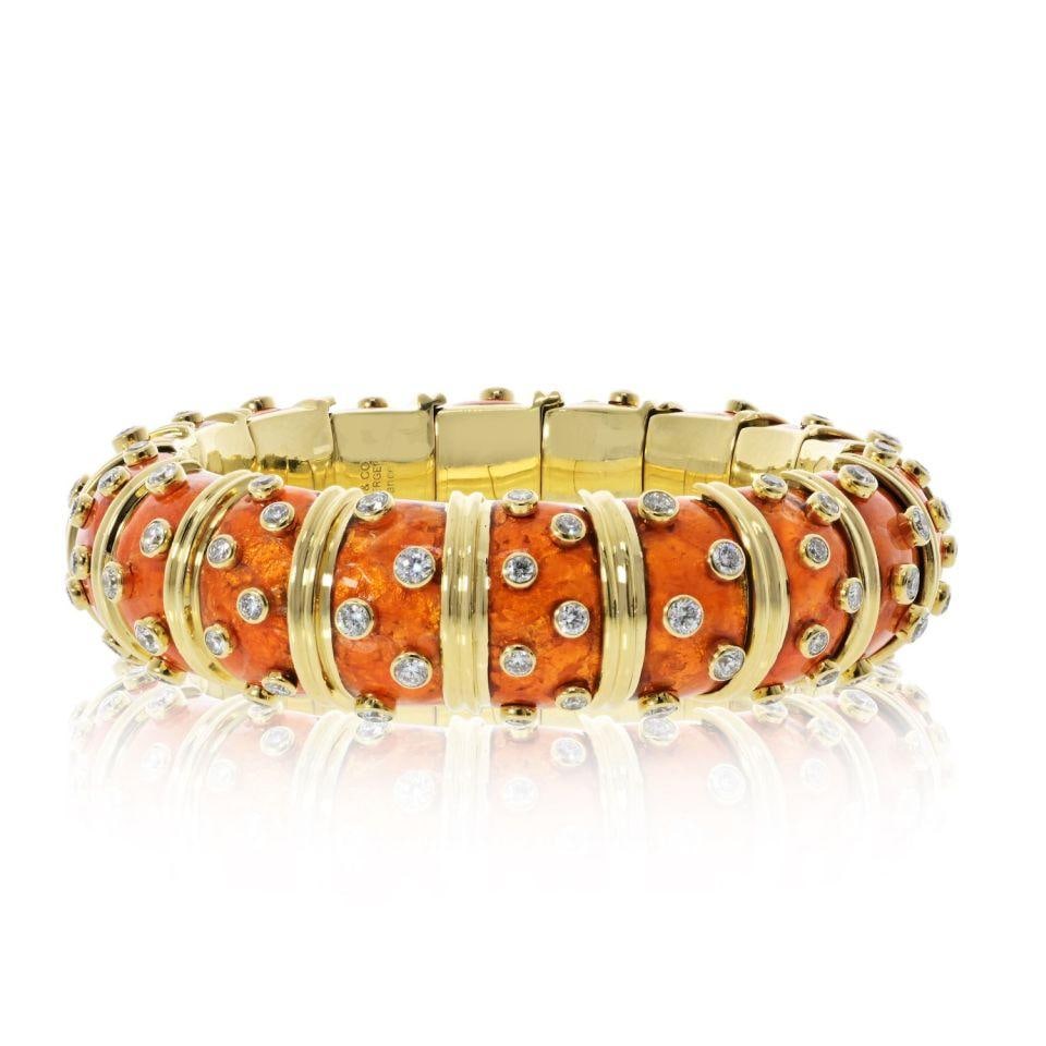 Schlumberger Bracelet in 18K Gold with Orange Enamel and Diamonds by Tiffany & Co.: Schlumberger Bracelet in 18K Gold with Orange Enamel and Diamonds by Tiffany & Co. This Tiffany & Co. Schlumberger bracelet is crafted from 18K yellow gold and features vibrant orange enamel accents. 