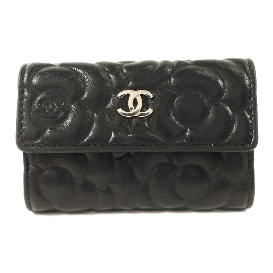 Black Calfskin Camellia Key Holder with Silver Tone CC by CHANEL: Black Calfskin Camellia Key Holder with Silver Tone CC by CHANEL This Chanel key pouch features a camellia embossed design crafted from black calfskin leather. Designed for women, it offers both elega