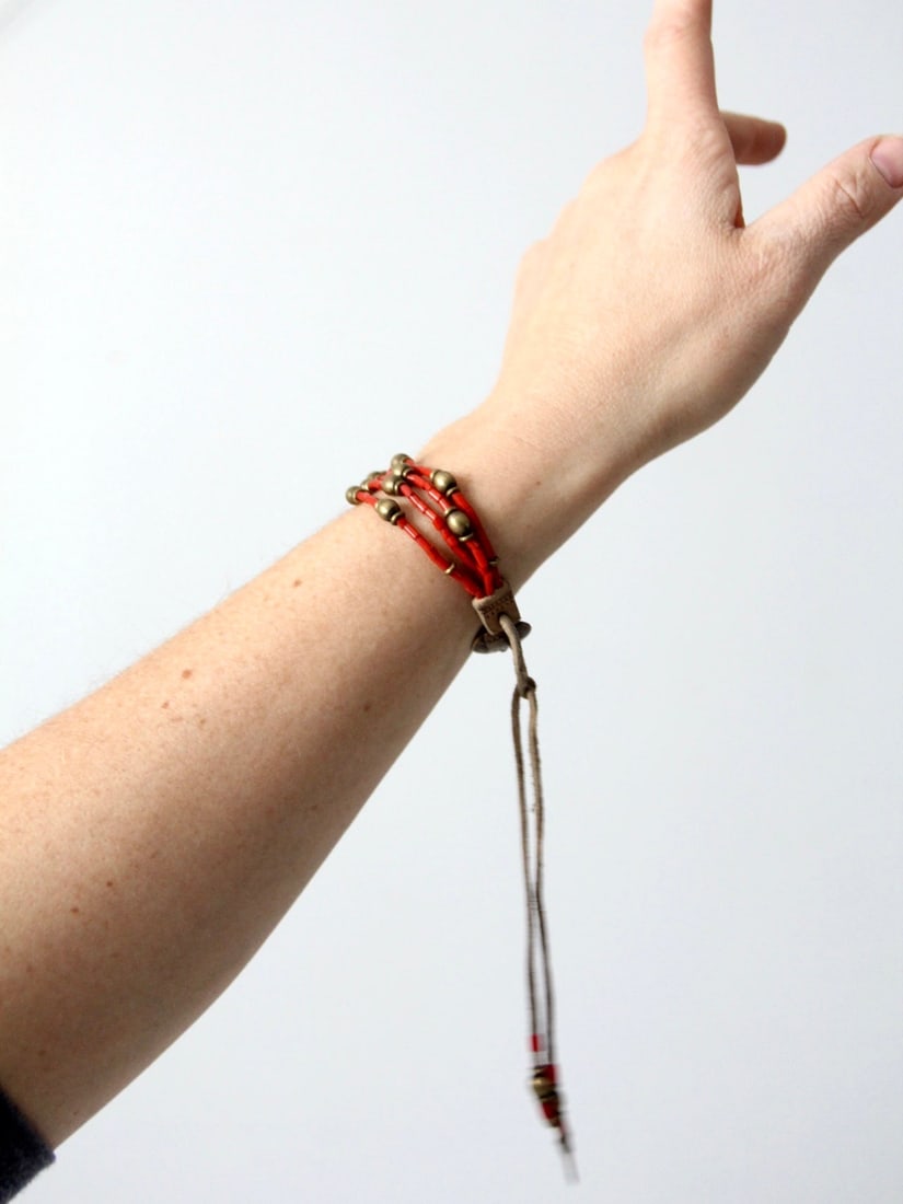 Vintage Boho Adjustable Beaded Bracelet with Copper Medallion: Vintage Boho Adjustable Beaded Bracelet with Copper Medallion Embrace a boho vintage aesthetic with this exquisite beaded bracelet. Crafted from slender leather strands, this bracelet features a capti