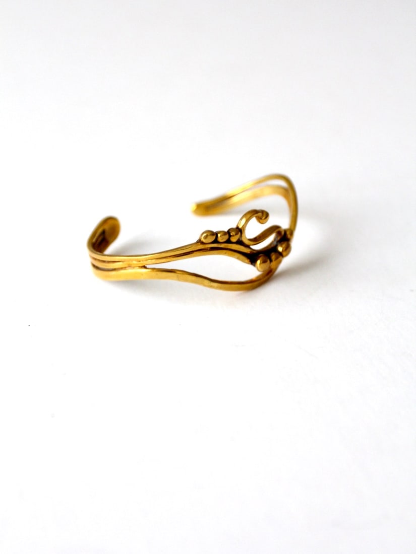 Vintage Brutalist Brass Cuff Bracelet with Dotted Design: Vintage Brutalist Brass Cuff Bracelet with Dotted Design Discover the elegance of our Vintage Brutalist Cuff Bracelet, a striking piece from our Stylist's Collection. This slender brass bracelet featu