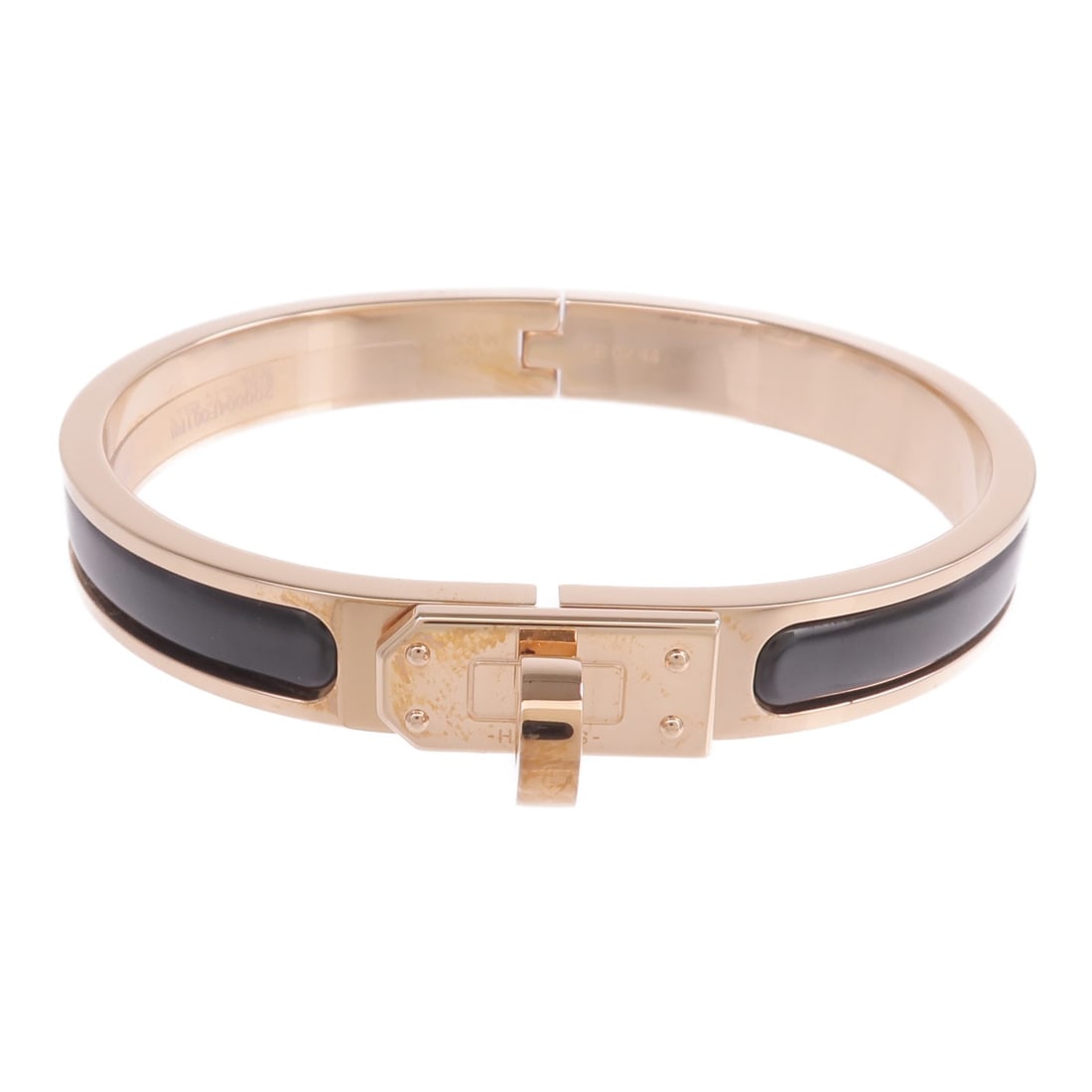 Mini Clic Kelly Black Enamel and Gold Bracelet by Hermes: Mini Clic Kelly Black Enamel and Gold Bracelet by Hermes This Hermes Mini Clic Kelly bracelet features black enamel set in metal with a gold finish. Designed for women, it showcases a sleek and elegan