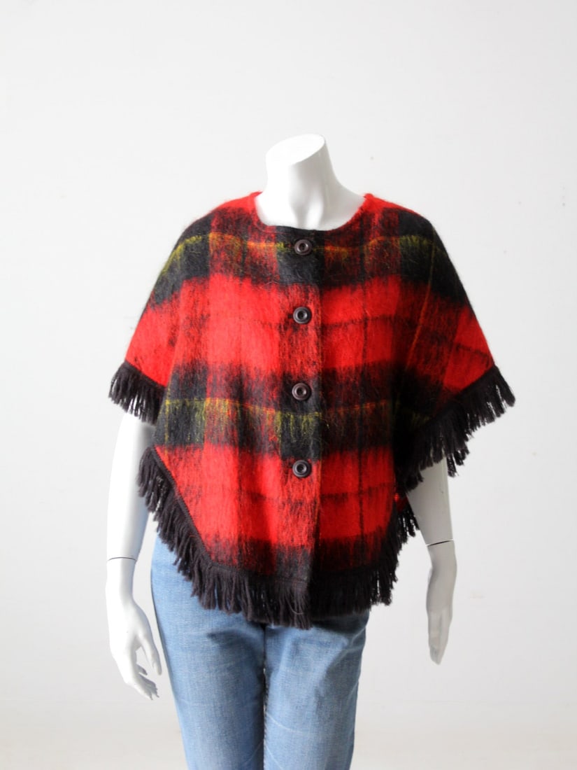 Vintage Mohair Poncho Sweater Red Black Plaid Fringe Detail: Vintage Mohair Poncho Sweater Red Black Plaid Fringe Detail This captivating vintage mohair plaid sweater combines style and comfort. Designed as a poncho, it showcases a striking red and black classi