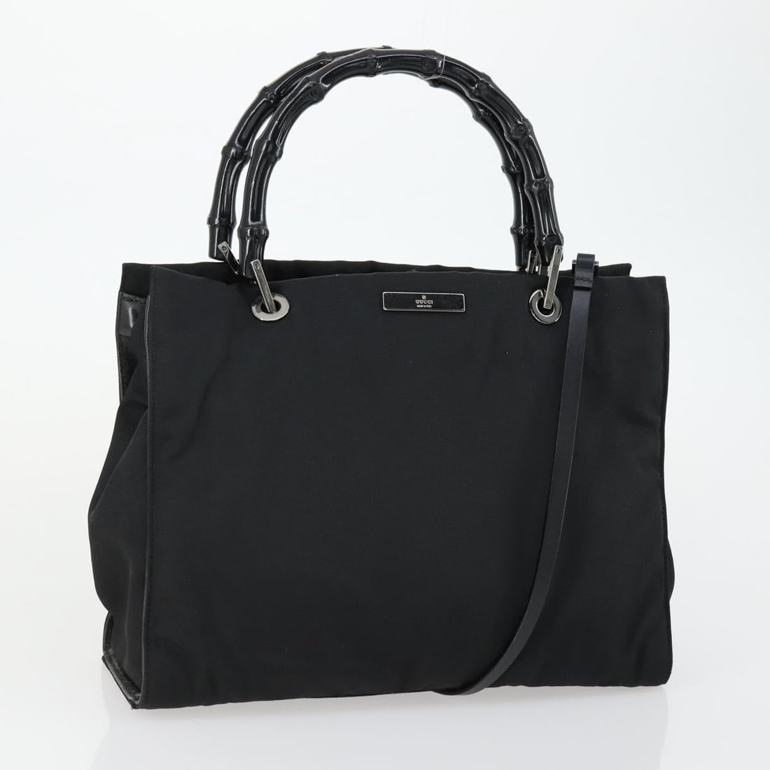 Black Nylon Gucci Tote with Bamboo Handles for Women: Black Nylon Gucci Tote with Bamboo Handles for Women This Gucci Bamboo Handle Tote is crafted from black nylon with bamboo handles. Designed for women, it features a spacious interior with minor disco