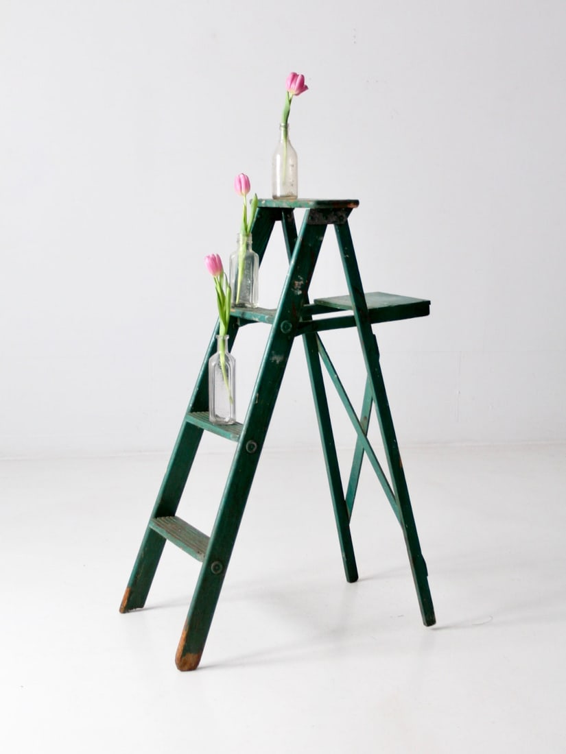 Charming Vintage Green Wooden A-Frame Ladder Decorative Storage: Charming Vintage Green Wooden A-Frame Ladder Decorative Storage Enhance your decor with this vintage green wooden ladder that exudes rustic charm. Its painted A-frame design is complemented by three g