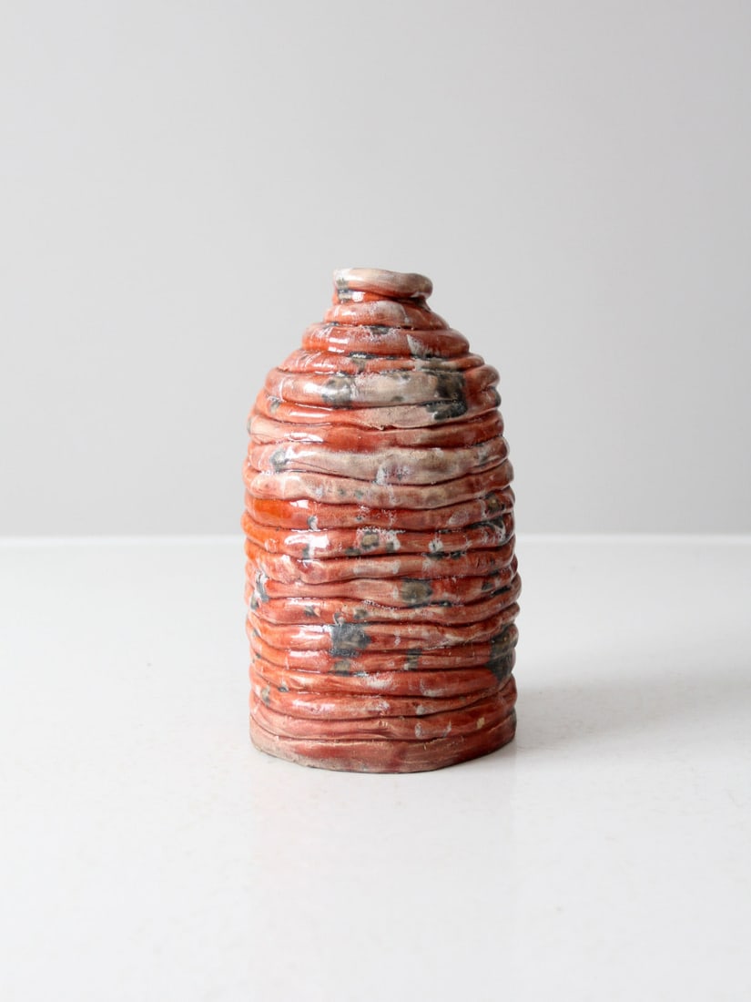Vintage Handcrafted Coral Glaze Pottery Vase by Round Boy: Vintage Handcrafted Coral Glaze Pottery Vase by Round Boy This vintage studio pottery vase showcases a unique hand-crafted free form design, featuring a striking ridge layered texture and a beautiful 