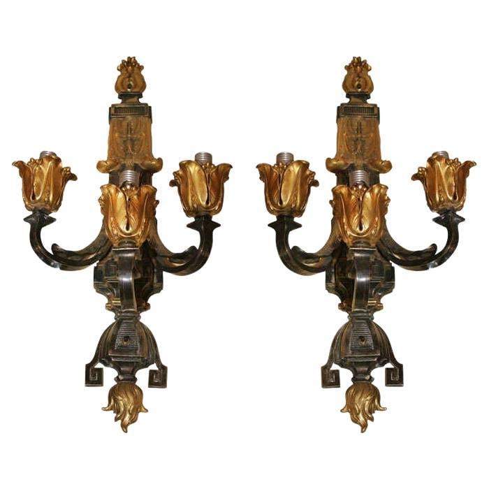 Set of 2 Neoclassical Gilt Patinated Bronze Three-Light Wall Sconces: Set of 2 Neoclassical Gilt Patinated Bronze Three-Light Wall Sconces This pair of large antique neoclassical sconces, crafted in the early 20th century, features gilt and patinated bronze construction