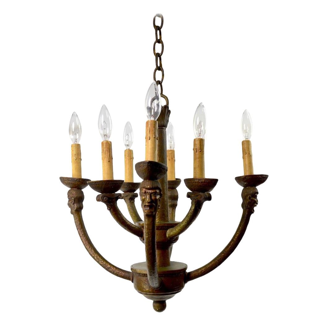 Bronze Eight-Light Gothic Mission Chandelier with Male Heads: Bronze Eight-Light Gothic Mission Chandelier with Male Heads Elevate your space with this stunning Eight-Light Greco Roman Revival Arts & Crafts Chandelier. This exquisite fixture features a cast bron