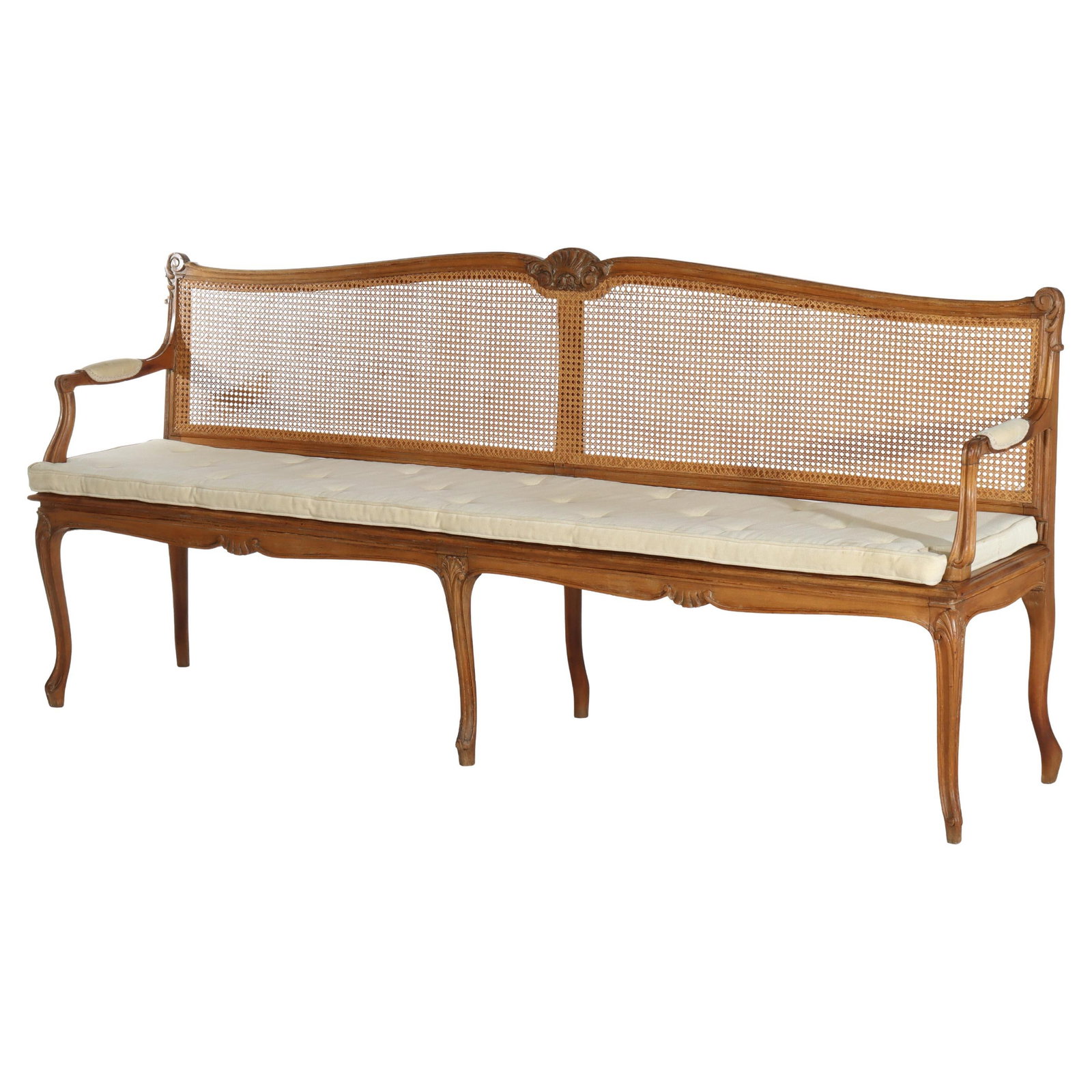 Early 20th Century French Mahogany and Cane Long Bench with Cushion: Early 20th Century French Mahogany and Cane Long Bench with Cushion This antique French Louis XV long bench dates to around 1910 and features elegant carved mahogany construction with cane panels. The