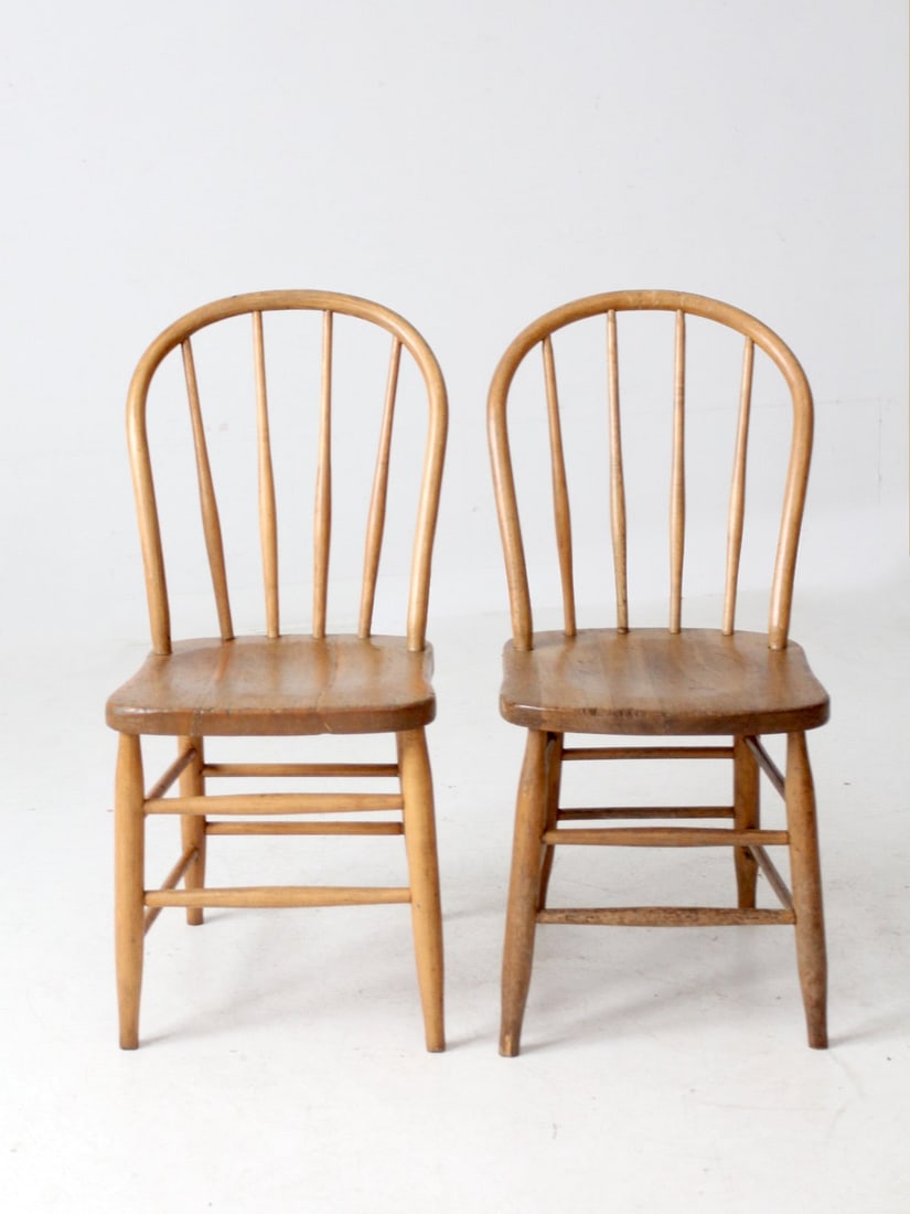 Antique Windsor Dining Chairs Pair with Spindle Backs: Antique Windsor Dining Chairs Pair with Spindle Backs This exquisite pair of antique Windsor-style bow back dining chairs showcases elegant spindle backs and gently contoured seats. Crafted from warm,