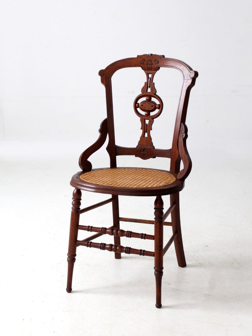 Victorian Eastlake Antique Chair with Cane Seat: Victorian Eastlake Antique Chair with Cane Seat This antique Victorian Eastlake chair showcases exquisite carved details and a beautifully sculptural backrest. The warm wood tone combined with a caned