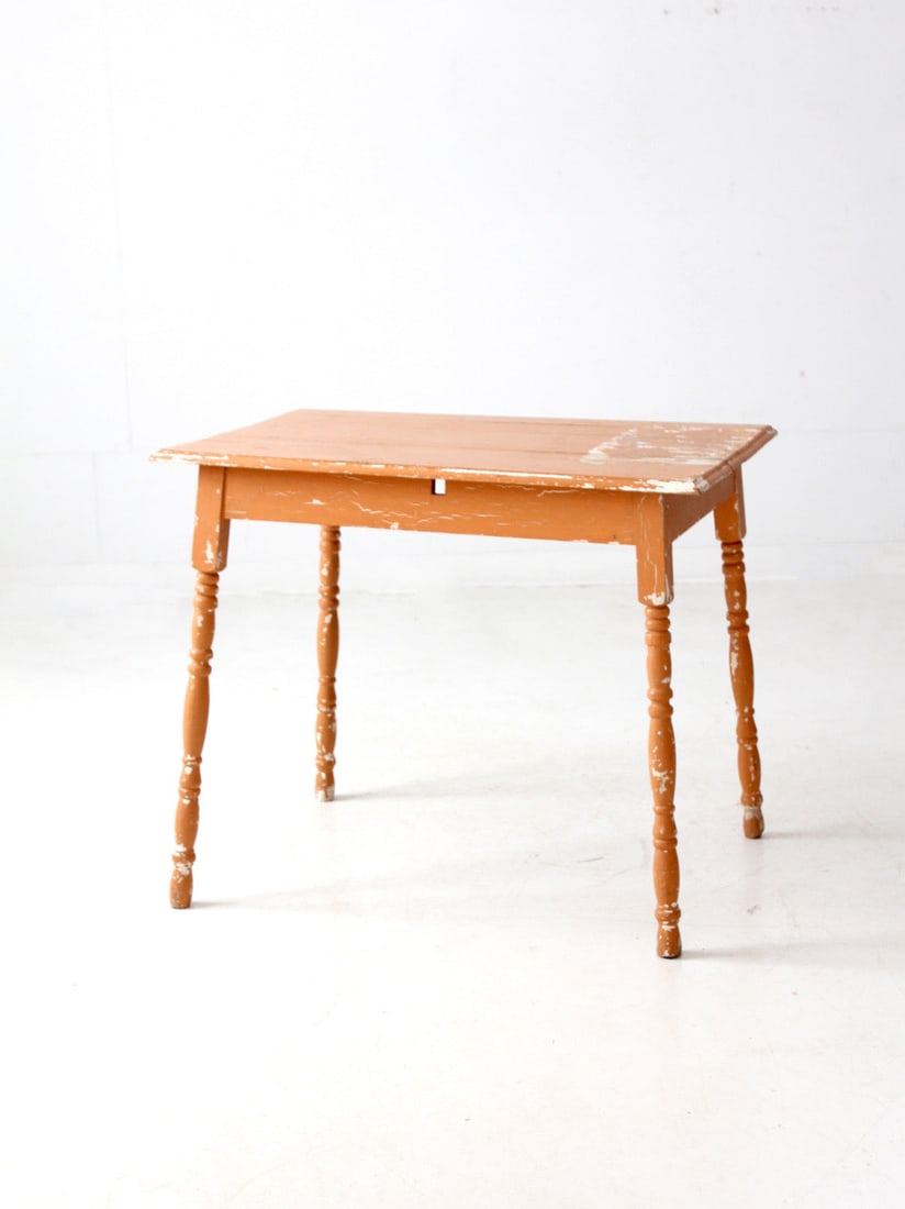 Antique Weathered Peach Wood Table with Classic Turned Legs: Antique Weathered Peach Wood Table with Classic Turned Legs This antique painted wood table showcases a charming weathered peach finish complemented by classic turned legs. It's a versatile addition t