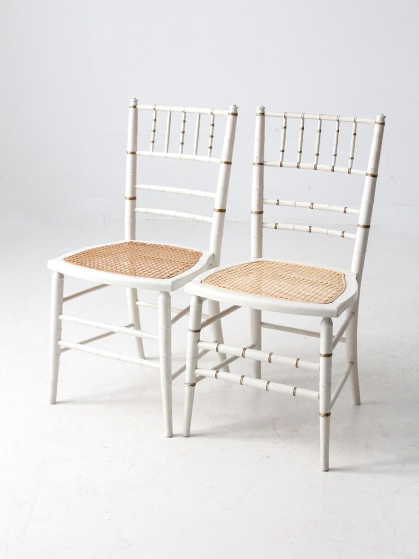 Antique White Chiavari-Style Cane Seat Chairs Pair with Brass Accents: Antique White Chiavari-Style Cane Seat Chairs Pair with Brass Accents This exquisite pair of antique white Chiavari-style chairs showcases beautifully crafted bamboo-turned frames and natural woven ca