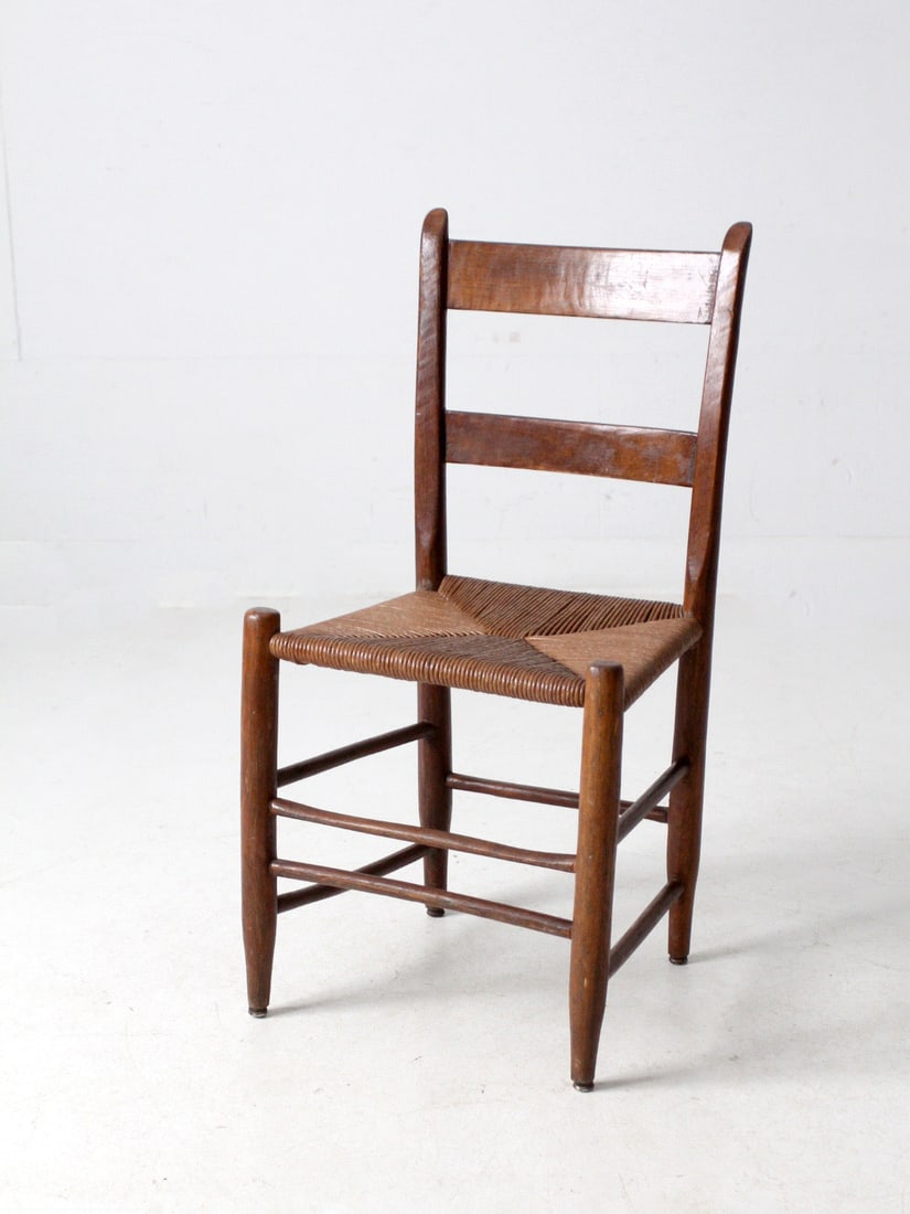 Classic Antique Ladder Back Chair with Woven Rush Seat: Classic Antique Ladder Back Chair with Woven Rush Seat This antique ladder back chair embodies the classic French country style, making it a charming addition to any space. It features a gracefully cu
