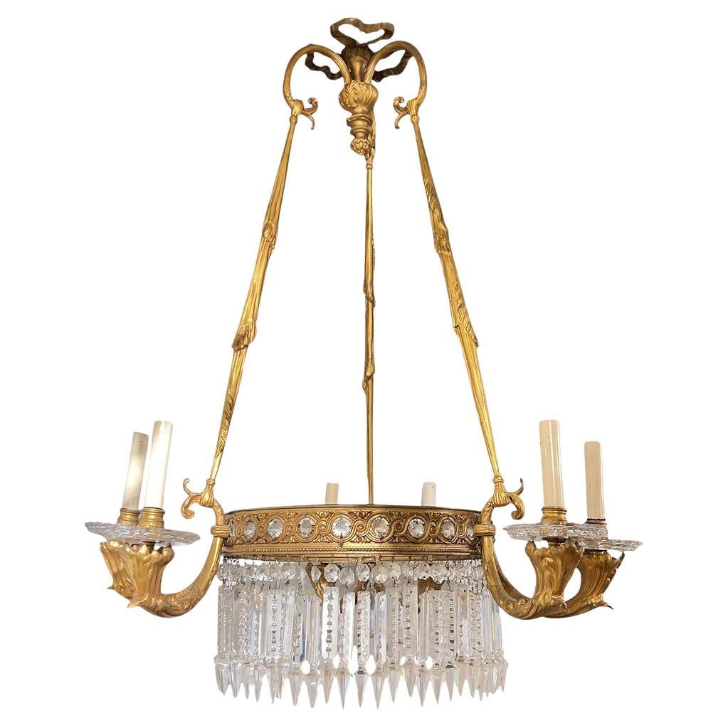 French Louis XVI Gilt Bronze Six-Arm Chandelier With Crystal Pendants: French Louis XVI Gilt Bronze Six-Arm Chandelier With Crystal Pendants This antique French Louis XVI style chandelier, dating to the late 19th century, features a reticulated central ring with a guillo