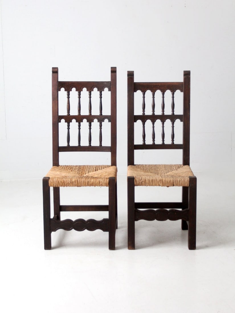 Rustic Spaniard Style Pair of Antique Rush Seat Chairs: Rustic Spaniard Style Pair of Antique Rush Seat Chairs This charming pair of early 20th century rush seat chairs showcases a rustic Spaniard style, featuring decorative turned spindle backs and intric