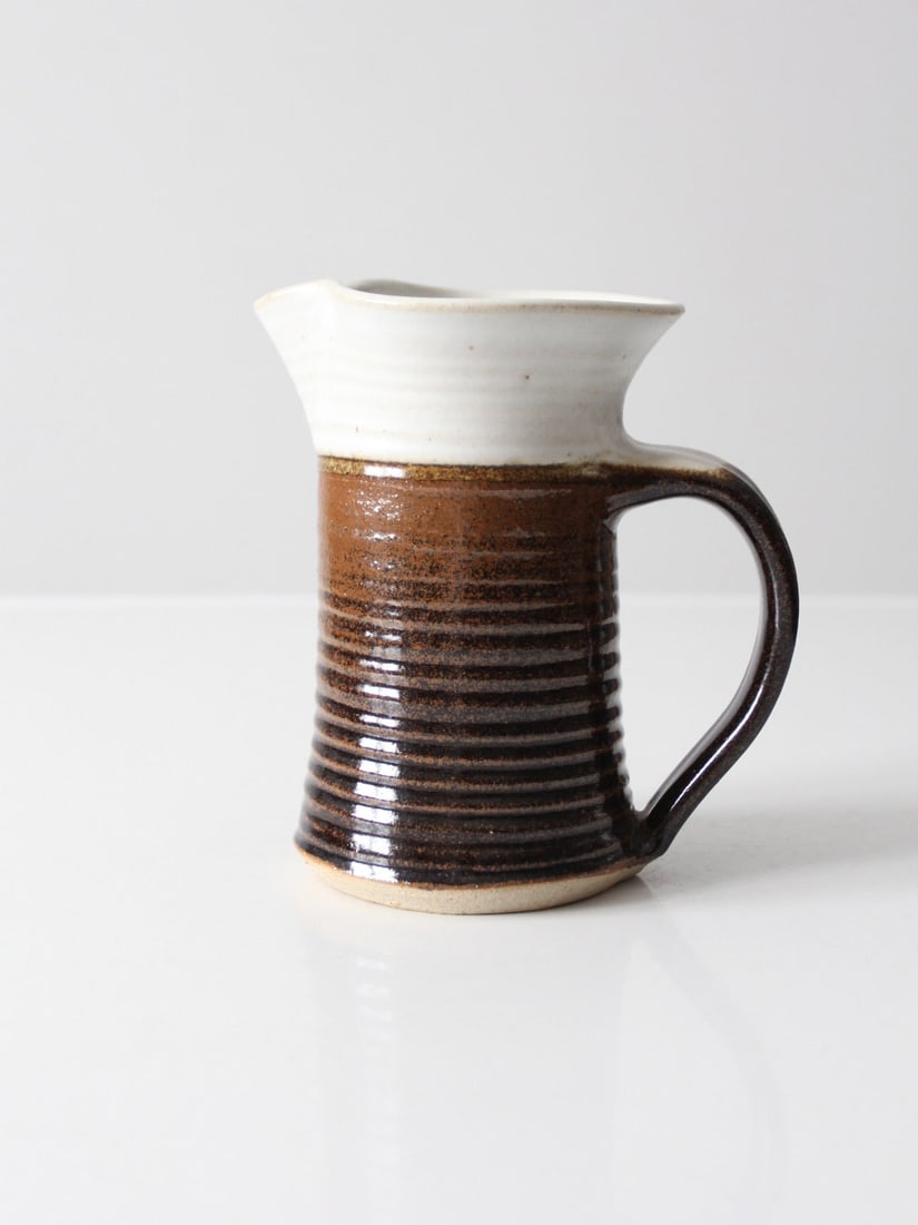 Vintage Signed Studio Pottery Pitcher Brown White Glaze 7 Inch: Vintage Signed Studio Pottery Pitcher Brown White Glaze 7 Inch This exquisite vintage studio pottery pitcher showcases a beautiful hand-crafted design with a stunning brown and white glaze. The base i