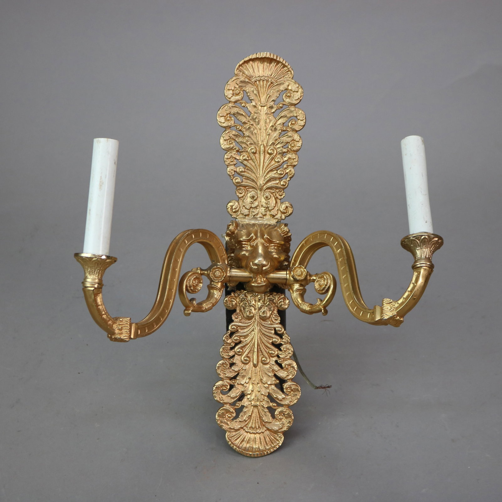 Bronze Two-Light Wall Sconce Featuring Gilt Lion Head Design 20th Century: Bronze Two-Light Wall Sconce Featuring Gilt Lion Head Design 20th Century This gilt bronze wall sconce features a figural design with a lion head motif. Crafted in the 20th century, it offers two ligh
