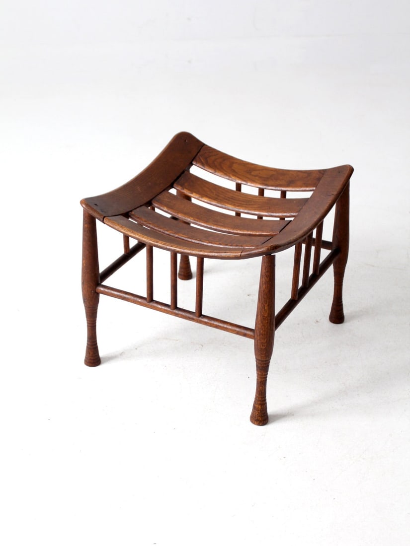 Antique Thebes Stool Egyptian Revival Oak Accent: Antique Thebes Stool Egyptian Revival Oak Accent This antique Thebes stool features a stunning Egyptian Revival design, characterized by a gracefully curved slatted seat and elegantly splayed legs. Cr