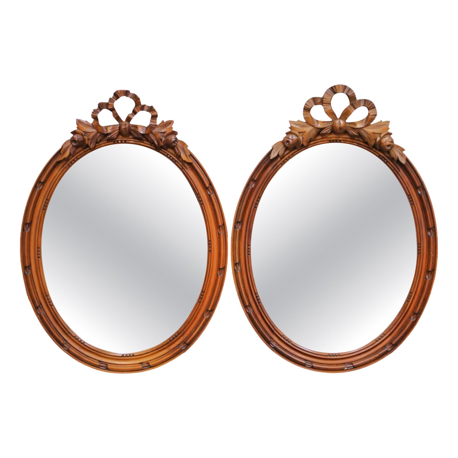 Set of Two French Oval Walnut Mirrors with Carved Ribbon Crest circa 1880: Set of Two French Oval Walnut Mirrors with Carved Ribbon Crest circa 1880 This pair of antique French Louis XVI oval mirrors, crafted circa 1880, features hand-carved walnut frames with a rich patina 