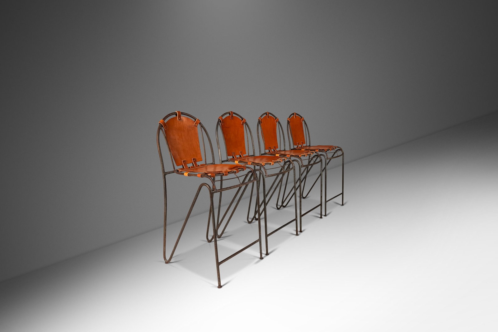 Rare Set of 4 French Industrial Barstools by Jacques Adnet with Leather Seats: Rare Set of 4 French Industrial Barstools by Jacques Adnet with Leather Seats This ultra-rare set of four French wrought iron barstools, inspired by the designs of Jacques Adnet, showcases a blend of 