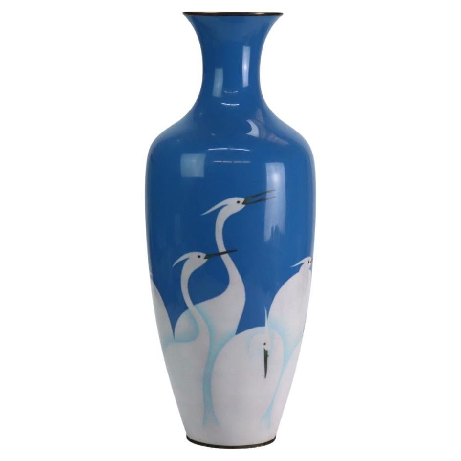 Early 20th Century Enameled Copper Floor Vase with Heron Motif: Early 20th Century Enameled Copper Floor Vase with Heron Motif This early 20th-century enameled copper floor vase features a depiction of herons set against a blue background. Crafted around 1920, the