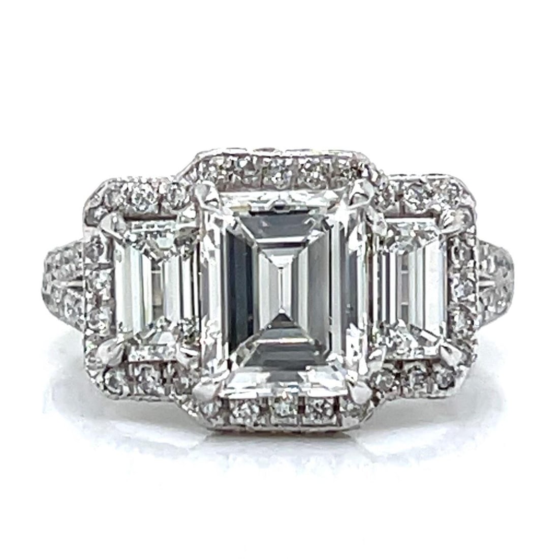 GIA Certified Platinum Three Stone Emerald Cut Diamond Ring: GIA Certified Platinum Three Stone Emerald Cut Diamond Ring This platinum ring features a central GIA certified 2.03 carat emerald-cut diamond with F color and SI1 clarity, flanked by two emerald-cut 