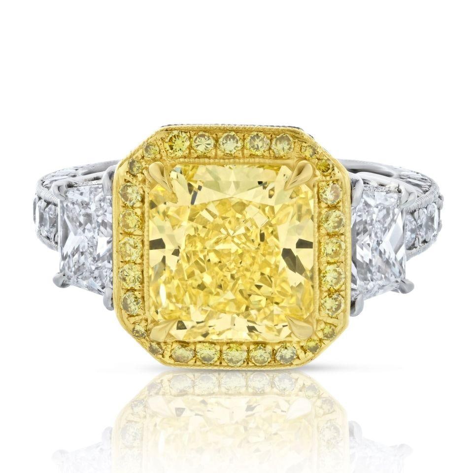 Radiant Cut Fancy Intense Yellow Diamond Three Stone GIA Platinum Ring: Radiant Cut Fancy Intense Yellow Diamond Three Stone GIA Platinum Ring This exquisite Fancy Yellow Ring is a stunning blend of platinum and 18K yellow gold, expertly crafted in a vintage style. The ce