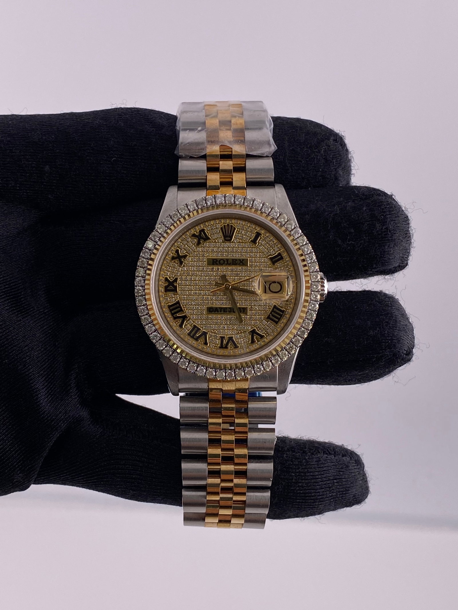 Prong Bezel Iced Roman Dial Rolex 1601 with Aftermarket Jubilee Bracelet: Prong Bezel Iced Roman Dial Rolex 1601 with Aftermarket Jubilee Bracelet This Rolex Datejust watch features an Iced Out Roman dial and a prong plated bezel. It is equipped with an Aftermarket Jubilee 