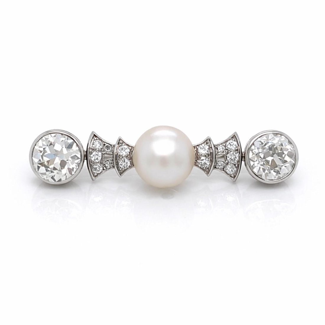 Platinum Art Deco Brooch with Natural Pearl and Diamonds 1.5 Inch: Platinum Art Deco Brooch with Natural Pearl and Diamonds 1.5 Inch This Art Deco brooch is crafted in platinum and features a natural pearl measuring 8.92mm, complemented by two diamonds with an approx