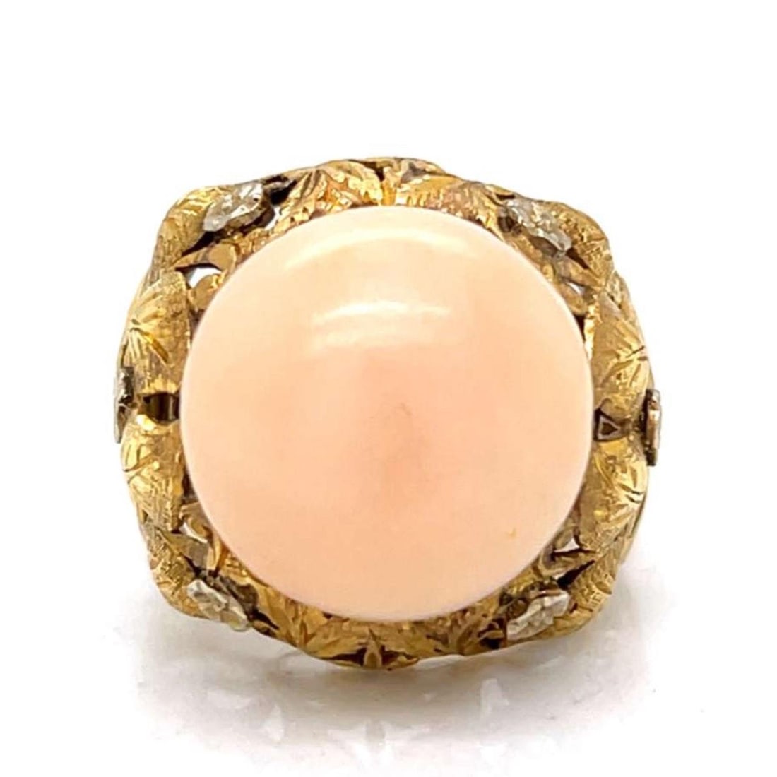 Angelskin Coral and 18K Gold Ring from the 1960s Era: Angelskin Coral and 18K Gold Ring from the 1960s Era This 1960s ring features a 14.0mm Angelskin coral set in 18K yellow gold. The ring is pre-owned and weighs 10.7 grams. It is sized at 5.5. Specific