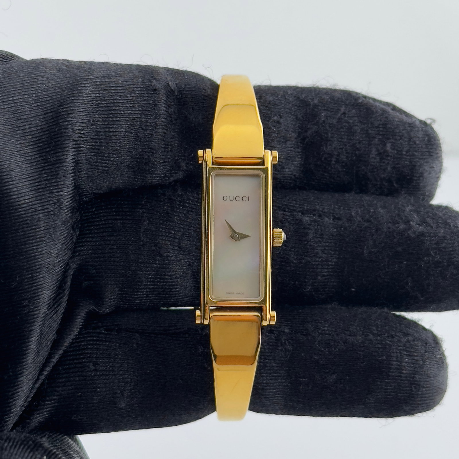 Ladies Gucci 1500L Bangle Watch with White Mother of Pearl Dial: Ladies Gucci 1500L Bangle Watch with White Mother of Pearl Dial This ladies' Gucci watch features a white mother-of-pearl dial and a sleek bangle-style bracelet. The watch is identified by reference n