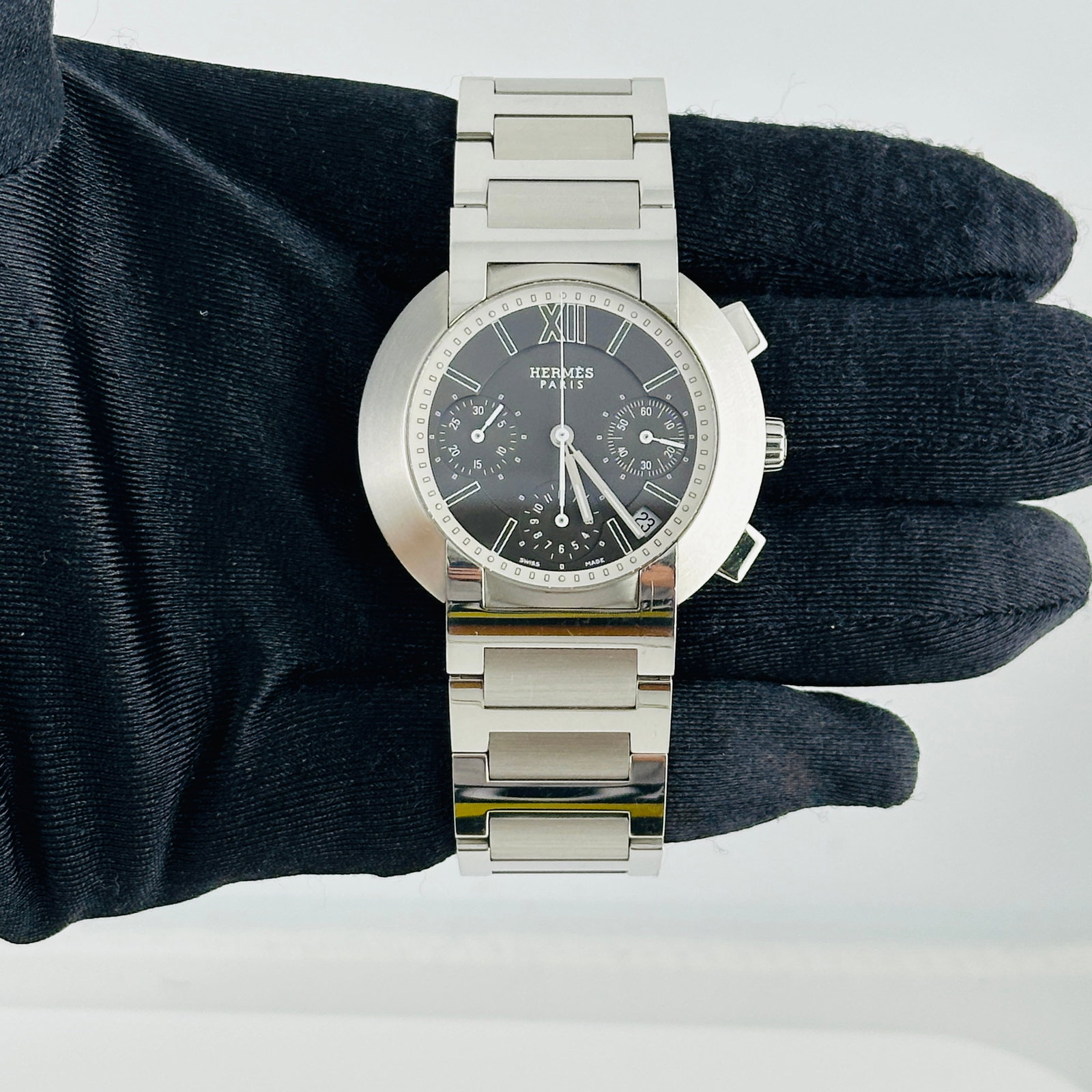 Hermes Nomad N01.910 Grey Dial Ladies Watch with Papers 2007: Hermes Nomad N01.910 Grey Dial Ladies Watch with Papers 2007 The Hermes Nomad ladies watch features a grey dial and a fixed bezel, complemented by a stainless steel bracelet. This timepiece is from th