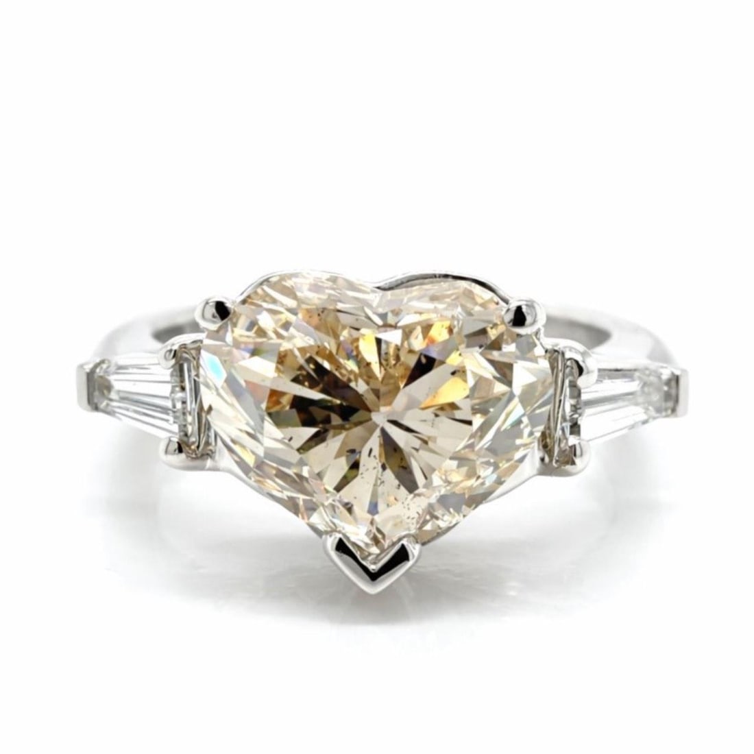 Platinum Ring with 4.51 Carat Heart-Shaped Diamond and Baguette Accents 1950s: Platinum Ring with 4.51 Carat Heart-Shaped Diamond and Baguette Accents 1950s This 1950s platinum ring features a 4.51 carat heart-shaped diamond with L color and SI2 clarity. The centerpiece is compl