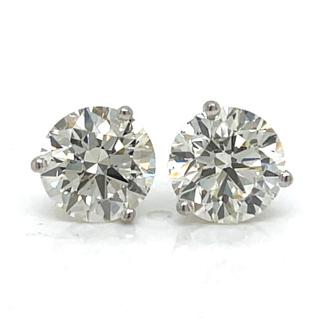 14K White Gold 5.00 Ct Round Diamond Studs Martini Mounting: 14K White Gold 5.00 Ct Round Diamond Studs Martini Mounting Elevate your elegance with these stunning 14K White Gold Diamond Stud Earrings. Featuring two round diamonds with a total weight of approxim