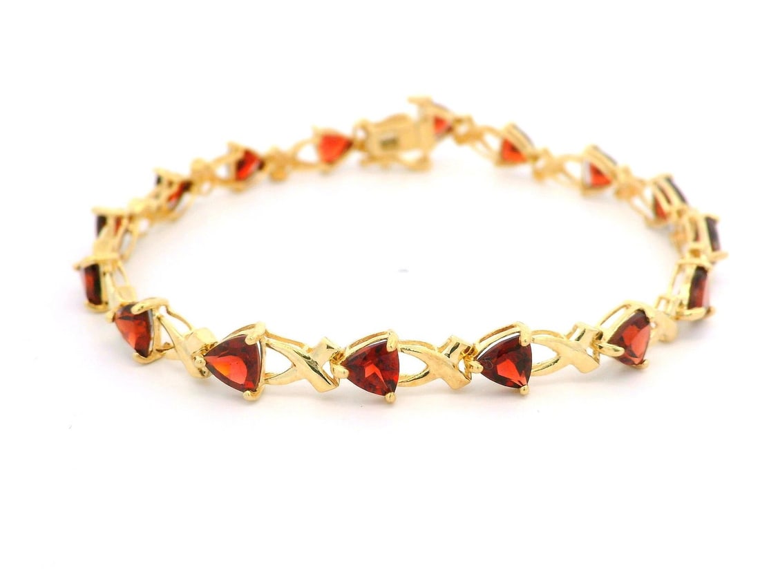 Estate 10k Yellow Gold Trillion Garnet Tennis Bracelet 7in: Estate 10k Yellow Gold Trillion Garnet Tennis Bracelet 7in This exquisite estate bracelet features a stunning line of natural genuine garnets, each with a trillion cut and prong set to showcase their 