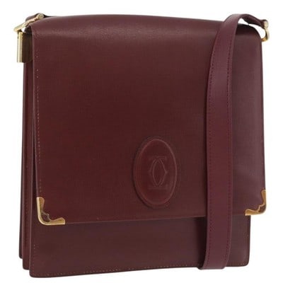 Cartier Must Line Bordeaux Leather Shoulder Bag Gold Tone: Cartier Must Line Bordeaux Leather Shoulder Bag Gold Tone This Cartier Must Line shoulder bag features a Bordeaux leather exterior with gold-tone accents. The bag is designed with a compact silhouette