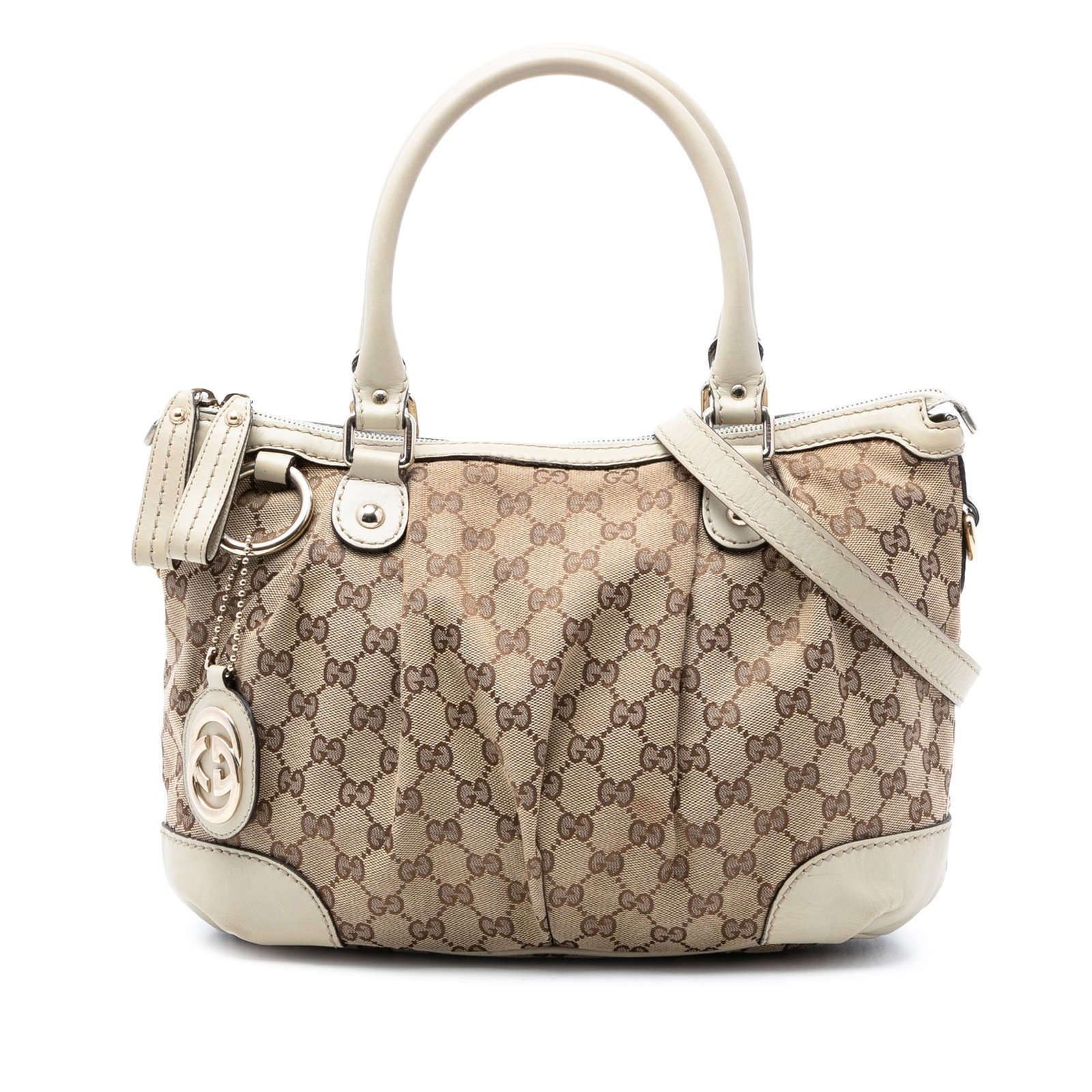 Beige GG Canvas Sukey Satchel with Leather Trim by Gucci: Beige GG Canvas Sukey Satchel with Leather Trim by Gucci The Gucci GG Canvas Sukey Satchel features a canvas body with leather trim, rolled leather handles, a flat leather strap, top zip closure, and 